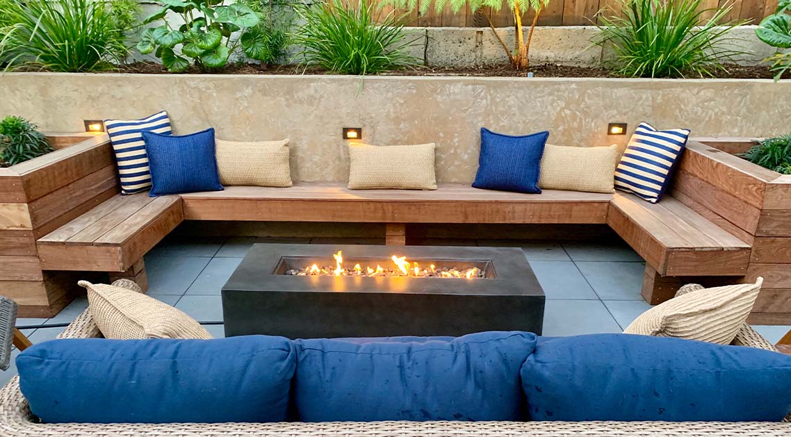 cushioned outdoor benches surrounding a raised fire pit